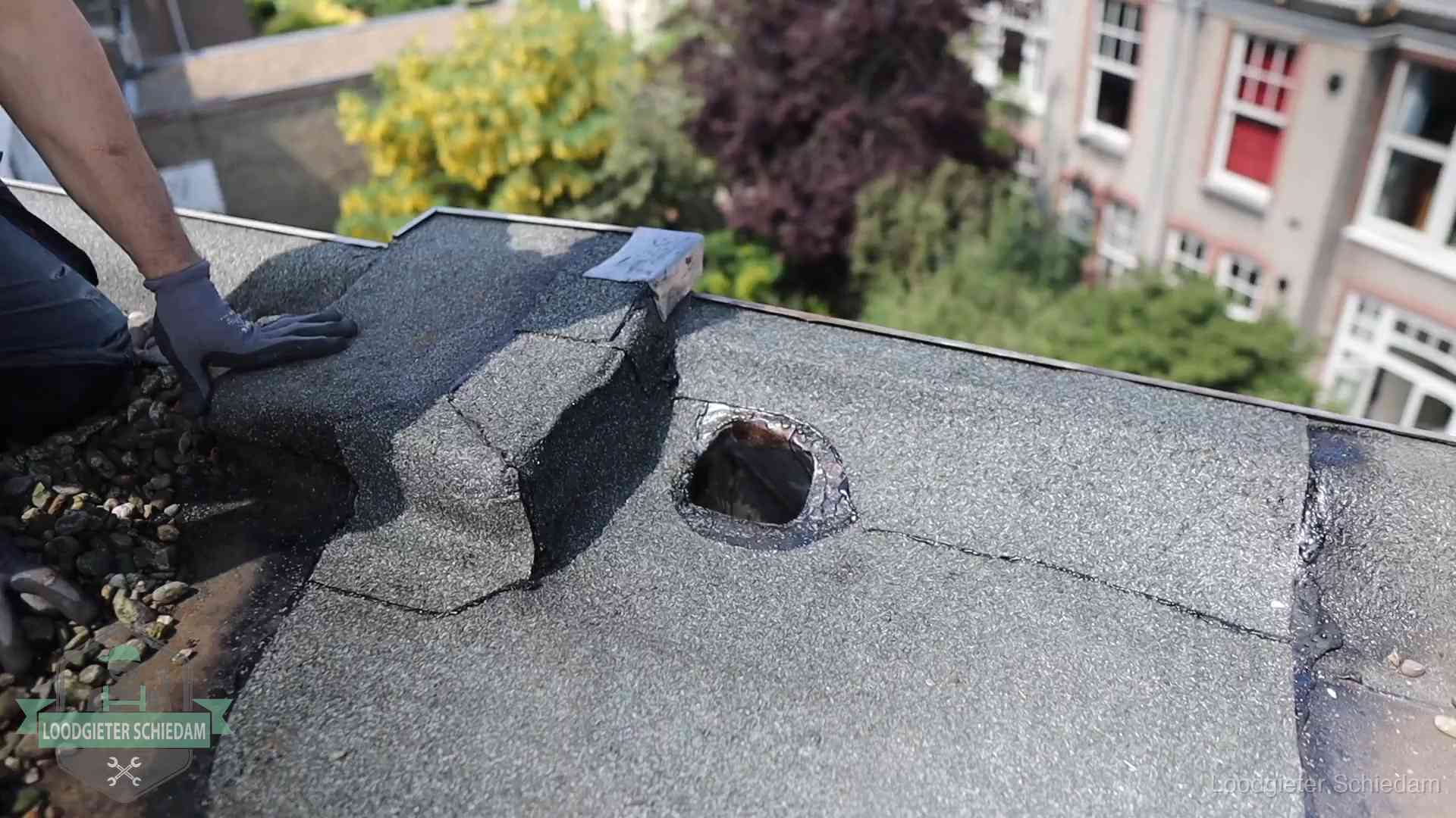 Daklekkage-inspectie op een plat dak in Schiedam Loodgieter inspecteert een beschadigd bitumen plat dak tijdens een daklekkage-inspectie in Schiedam