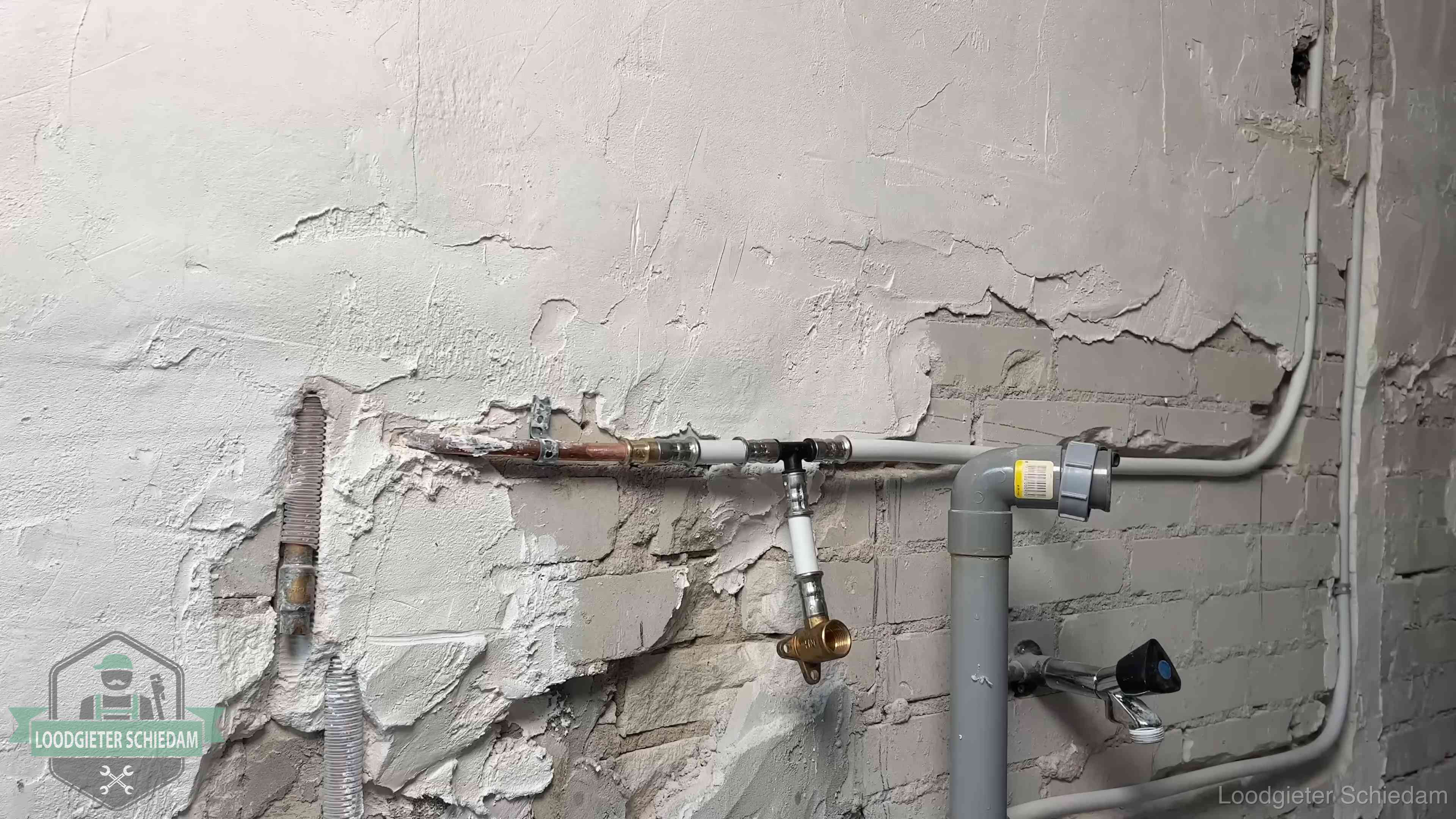 Nieuw leidingwerk naast een oud verroest leidingrestant in een woning in Schiedam