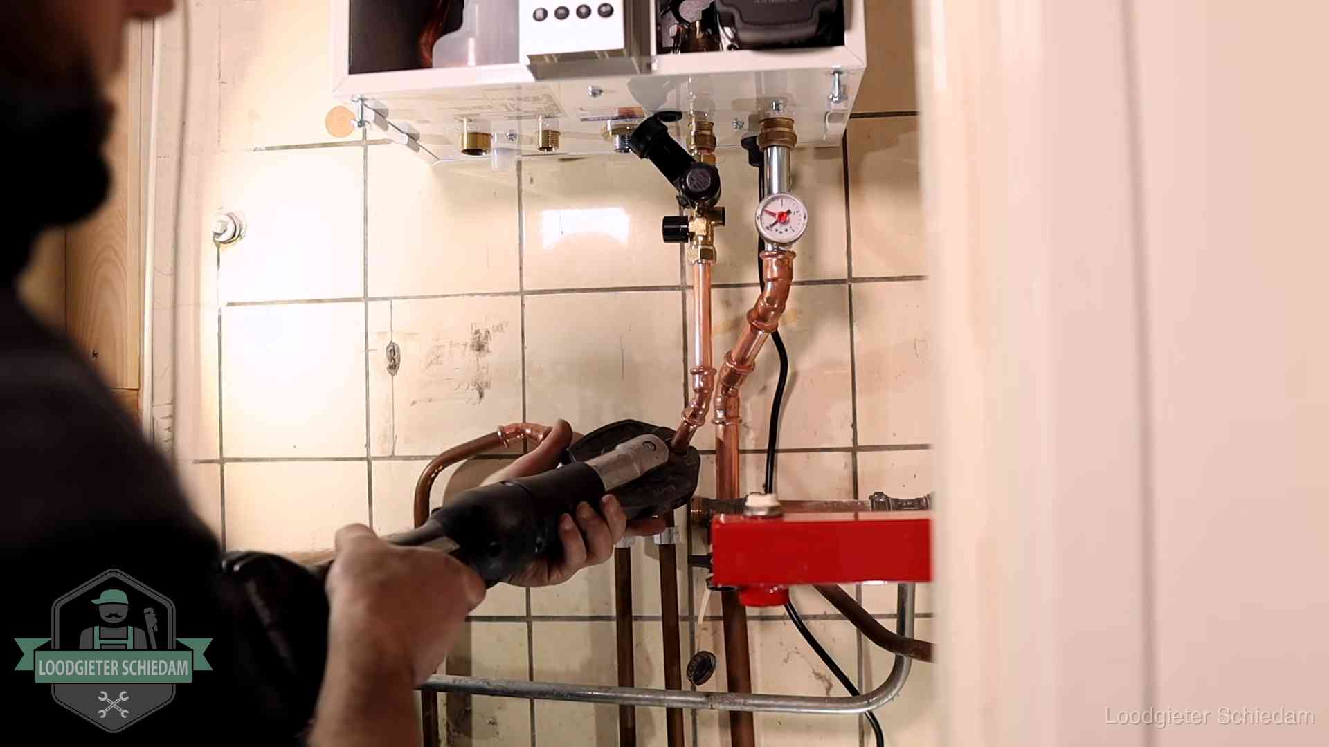 Cv-ketel onderhoud in Schiedam Monteur werkt aan de leidingen onder een cv-ketel in Schiedam