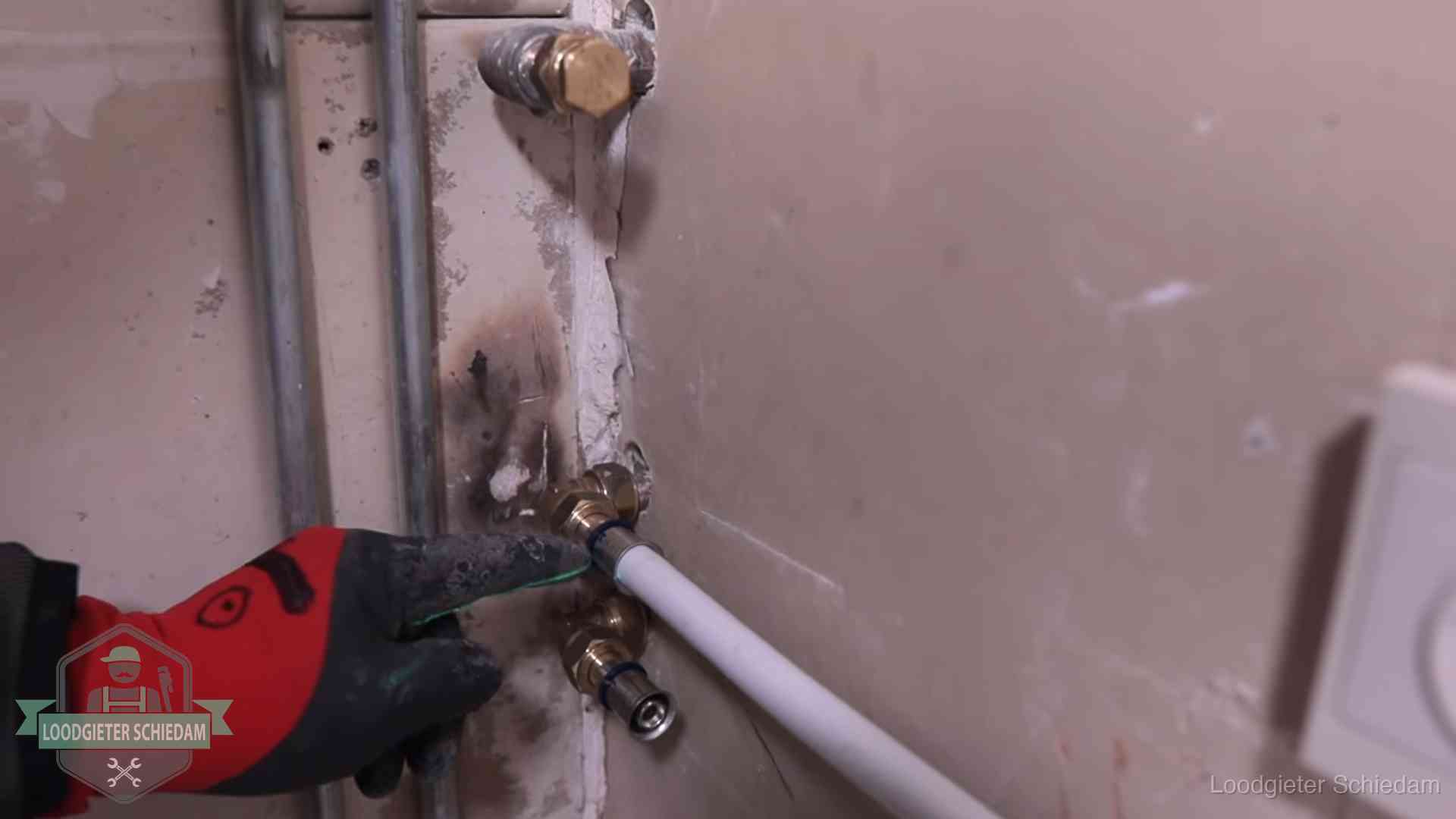 Loodgieter wijst de persfitting op nieuwe muuraansluitingen aan in een woning in Schiedam