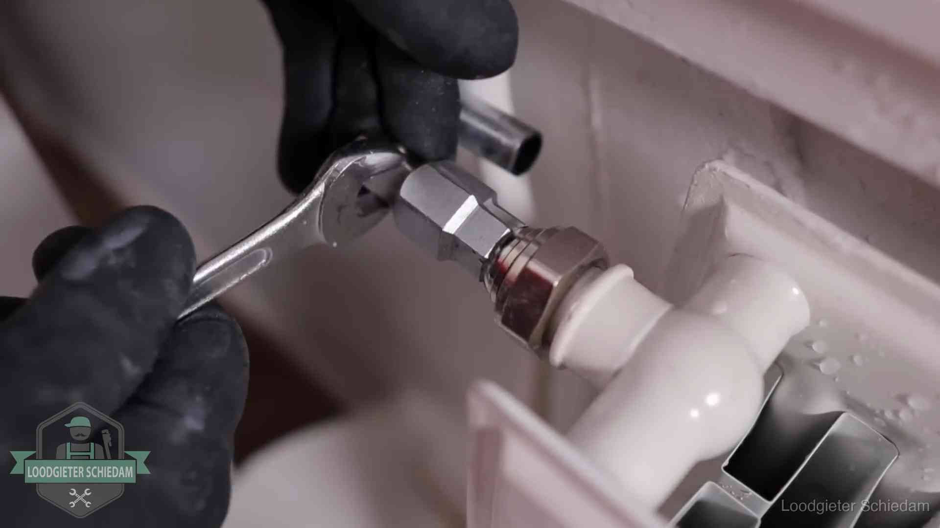Radiatoren en waterzijdig inregelen in Schiedam Steeksleutel draait een wartelkoppeling op een radiatorkraan aan in Schiedam
