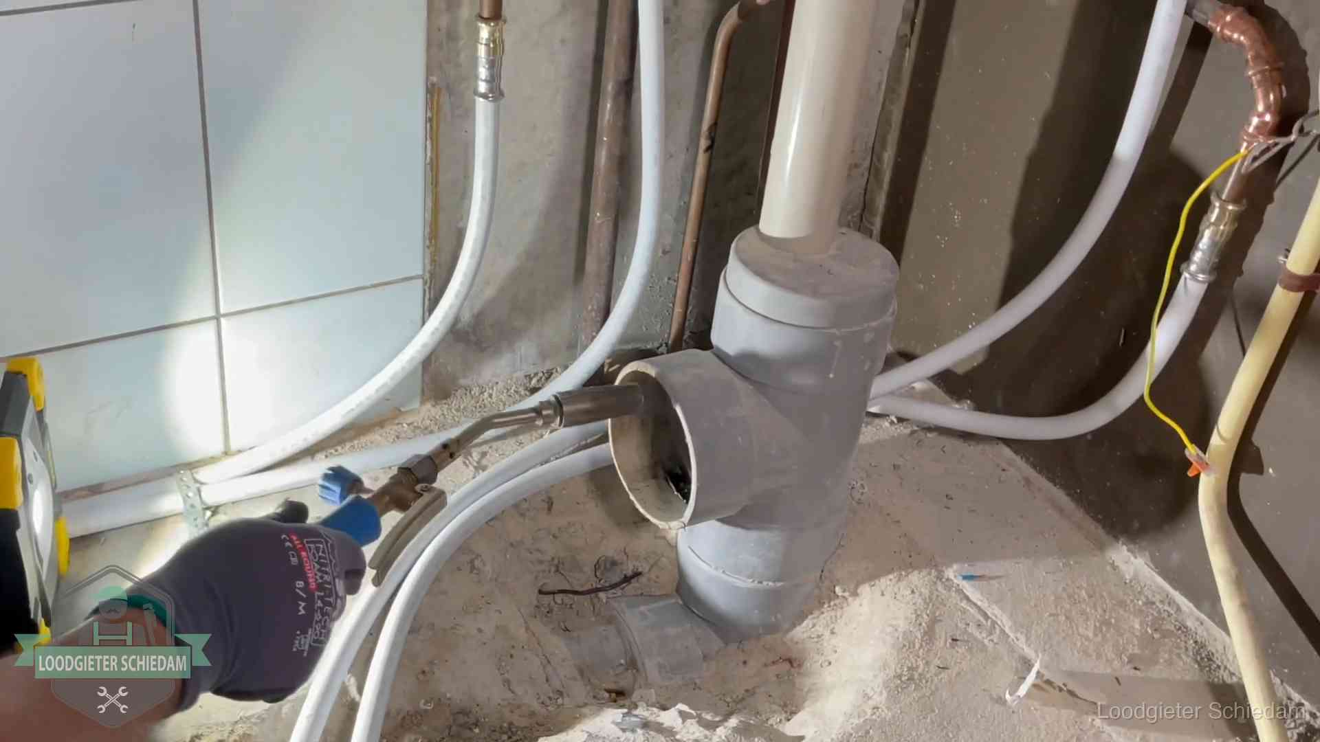 Loodgieter werkt aan leidingen bij de pvc-standleiding van een huurwoning in Schiedam