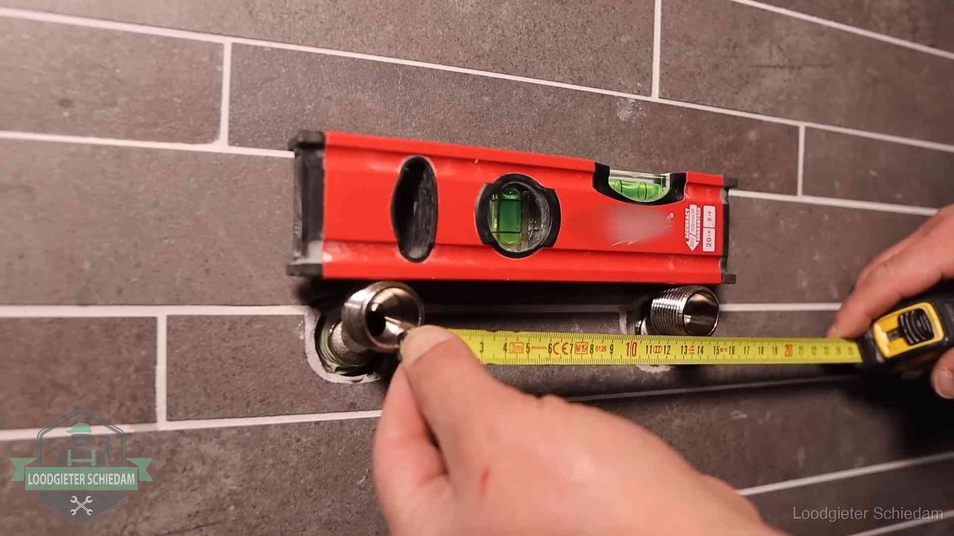 Waterpas en duimstok bij kraan-aansluitpunten in een badkamer in Schiedam