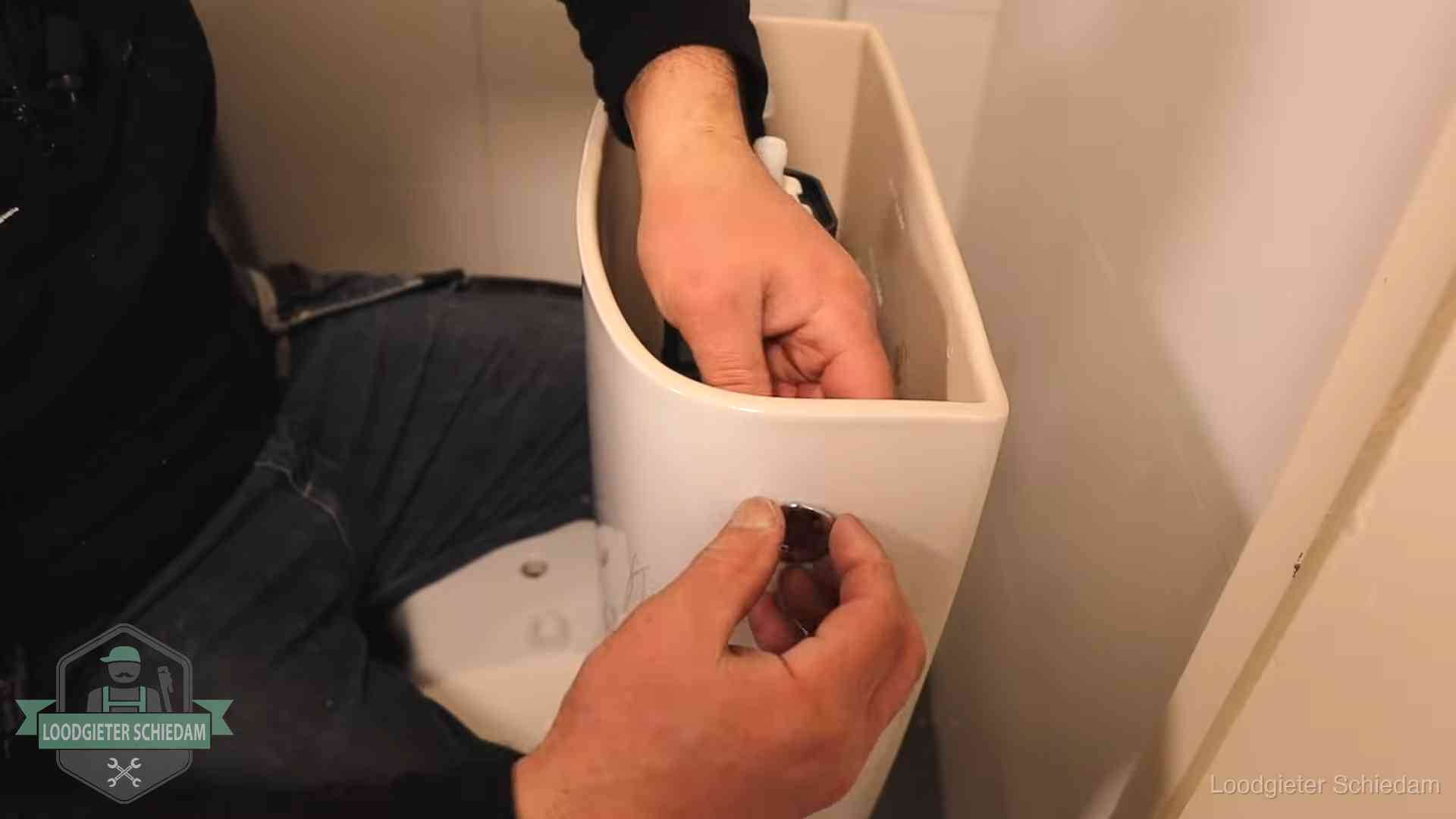 Je wc verstoppingsvrij houden in Schiedam Drukknop van een duoblok-stortbak wordt gemonteerd bij een toilet in Schiedam