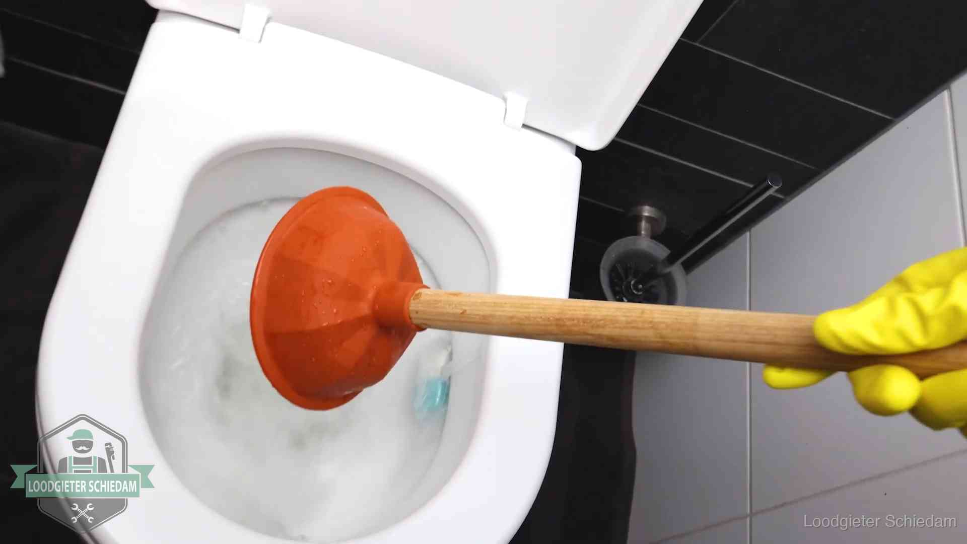 Wc ontstoppen met de plopper in Schiedam Plopper wordt in de wc-pot gedrukt bij het ontstoppen van een toilet in Schiedam