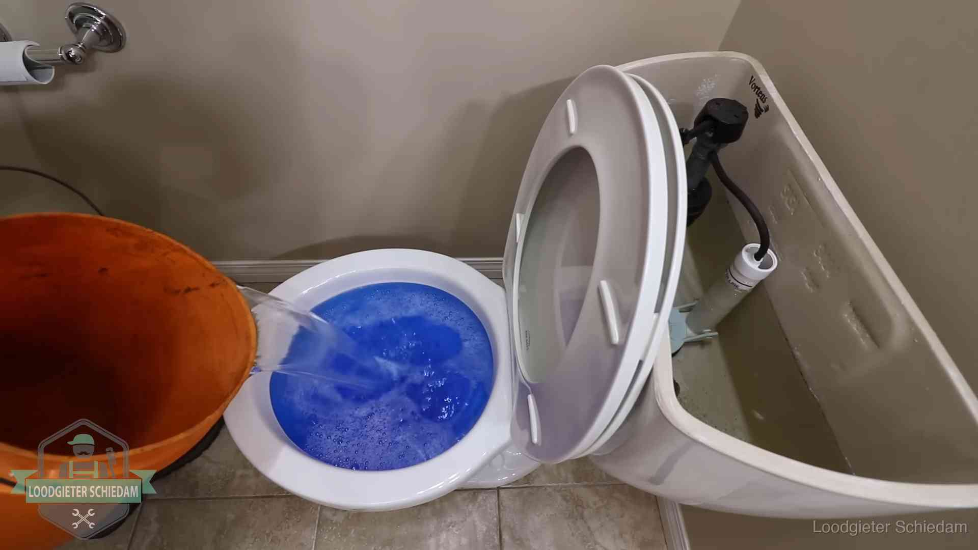 Water komt omhoog in de wc in Schiedam Water bij de wc-pot wordt met een emmer weggewerkt om schade te beperken in Schiedam